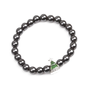 Detailed macro view of dark grey hematite beaded bracelet with green Christmas tree charm