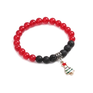 Detailed view of Christmas bracelet with red agate beads and a festive tree pendant