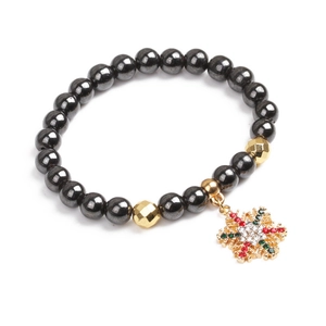 Nahaufnahme des Magnetperlenarmbands mit goldenem Schneeflockenanhänger und bunten Steinen