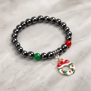 Dettaglio del bracciale di ematite con ciondolo natalizio a ghirlanda smaltata