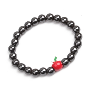 Detail of hematite beaded bracelet featuring a red apple charm with green leaf