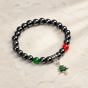 Dettaglio del bracciale in ematite con perle festive e ciondolo ad albero di Natale