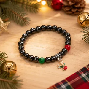 Dettaglio del bracciale in ematite magnetica con ciondolo a renna e perle natalizie