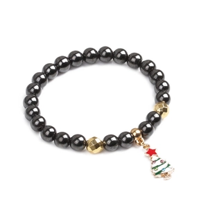 Detailaufnahme eines Magnet-Hämatit-Armbands mit süßem Weihnachtsbaum-Emaille-Anhänger