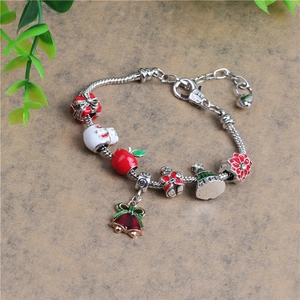Makro-Detail des Weihnachts-Schlangenarmbandes mit Emaille-Anhängern und Merry-Gravur