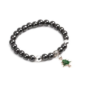 Detail eines magnetischen Hämatit-Perlenarmbands mit grünem Weihnachtsbaum-Anhänger