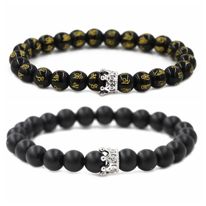 Detalle de pulseras de cuentas negras brillantes y mates con corona de plata y circonio