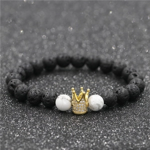 Detailed macro view of gold crown charm with micro-pave cubic zirconia on lava stone beads