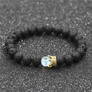 Lava stone bead crown bracelet with blue moonstone accent on a sparkling black surface