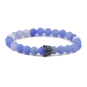 Detailaufnahme der 8mm blauen Perlen mit schwarzem Kronenanhänger auf Elastikarmband