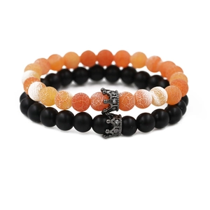 Set aus orangefarbenem Lavastein und schwarzen matten Perlenarmbändern mit Kronenanhänger