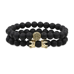 Set de dos pulseras de cuentas negras mates con coronas doradas y detalles de circonitas