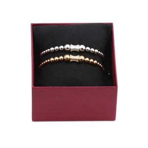 Set of two gold and silver beaded bracelets with micro-pave CZ funnel charms in a box