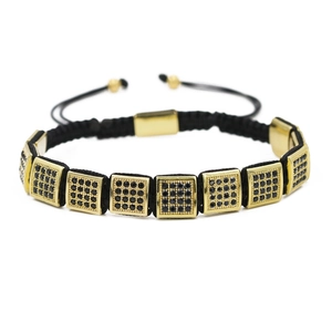 Détail d'un bracelet tissé main avec blocs dorés et oxydes de zirconium noirs micro-pave