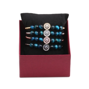 Four-piece evil eye bead bracelet set with blue tiger eye stones in a red gift box
