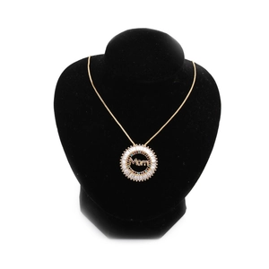 Gold Mom pendant necklace with zircon stones on a black velvet neck display