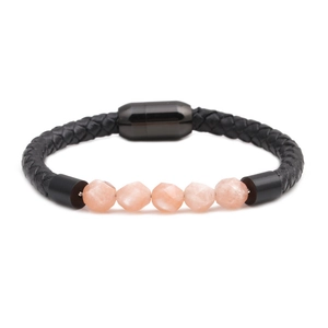 Detail of black braided leather bracelet with five faceted cat eye stones and magnetic clasp