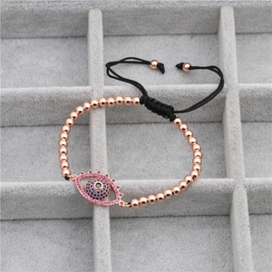 Detail of rose gold evil eye woven bracelet with blue and pink cubic zirconia inlay
