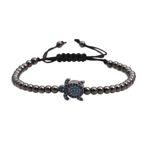 Bracelet tressé avec perles noires et pendentif tortue serti de zircons bleus