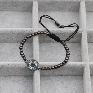 Detail view of evil eye bracelet with gunmetal beads and blue zircon charm on grey tray