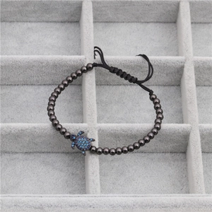 Détail du bracelet tissé ajustable avec perles de 4mm et breloque tortue sertie de zircons