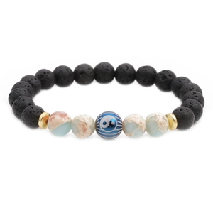 Yin Yang lava stone beaded bracelet with blue jasper and golden spacers on white background