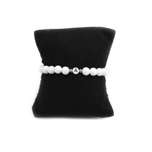 6mm white turquoise beaded bracelet with black letter A bead on a black display cushion