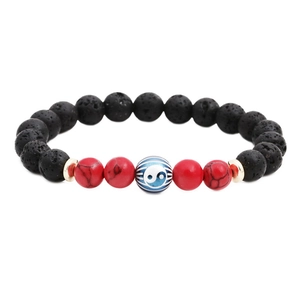 Vintage lava stone and red turquoise bracelet with Yin Yang charm on white backdrop