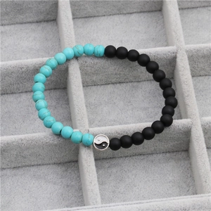 Macro detail of yin yang beaded bracelet with turquoise and matte black stone beads