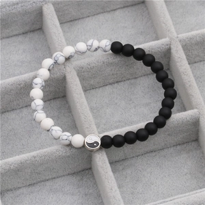 Close-up of Yin Yang elastic bracelet with matte black beads and white marble stones