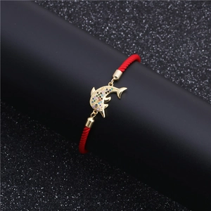 Adjustable red cord bracelet featuring a gold dolphin pendant with multi-color zircon stones