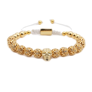 Dettaglio del bracciale intrecciato regolabile con teschio dorato e zirconi incastonati