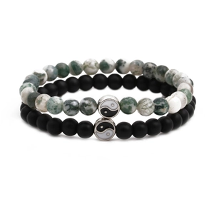 Detail of couple bracelets with matte black and patterned beads featuring Yin Yang charms