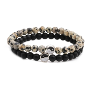 Close-up of matte black and marble bead distance bracelets with Yin Yang metal charms