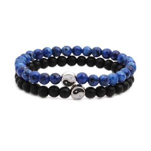 Detailed close-up of blue stone and matte black beads with Yin Yang charms on bracelets