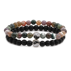 Detail view of couple bead bracelets with matte black stones and Yin Yang charms