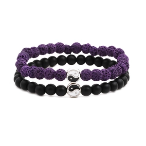 Macro detail of purple lava stone and black matte beads with yin yang charms