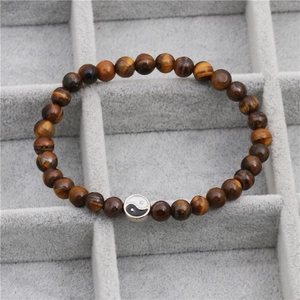 Macro detail van Tijgeroog kralenarmband met een klassieke Yin Yang symbool bedel