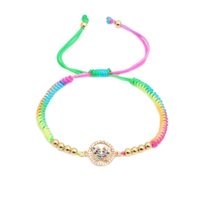 Detail of colorful woven bracelet with butterfly charm and gold bead accents