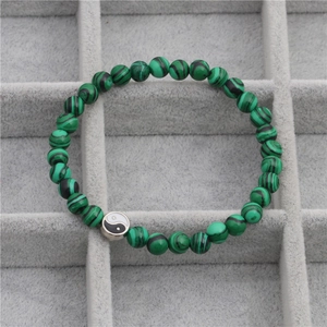 Macro-opname van Yin Yang-kraal op groene malachiet kralenarmband in een sieradendoos