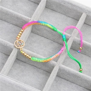 Detail of rainbow braided bracelet with colorful zircon butterfly pendant and gold beads