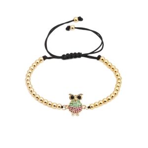 Adjustable woven bracelet featuring golden beads and micro-pave owl charm with colorful zircons