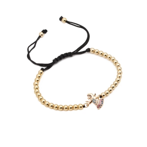 Detail of woven bracelet featuring golden beads and micro-inlaid zircon angel heart charm