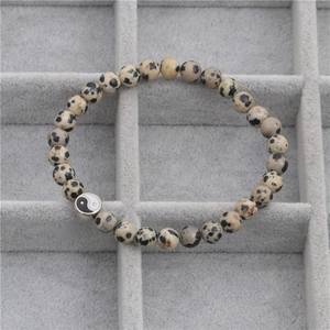 Macro-opname van Dalmatische Jaspis kralenarmband met Yin Yang bedel op een sieradenlade