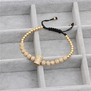 Macro detail of men's crown woven bracelet with golden beads and micro zircon spheres