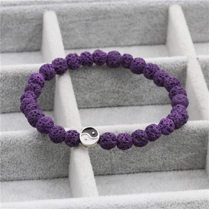 Detail van paarse lavasteen armband met Yin Yang bedeltje in een sieradenbakje