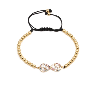 Bracelet infini avec zircons et perles dorées sur un cordon noir tressé et ajustable