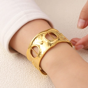 Wide gold plated stainless steel open cuff bracelet with hammered texture and hollow design