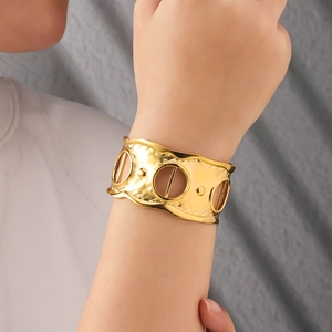 Adjustable wide gold hammered cuff bracelet with cutout circles and wavy edges for women