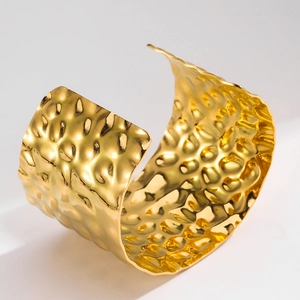 Macro detail of wide 18K gold plated cuff bracelet with unique hammered texture design